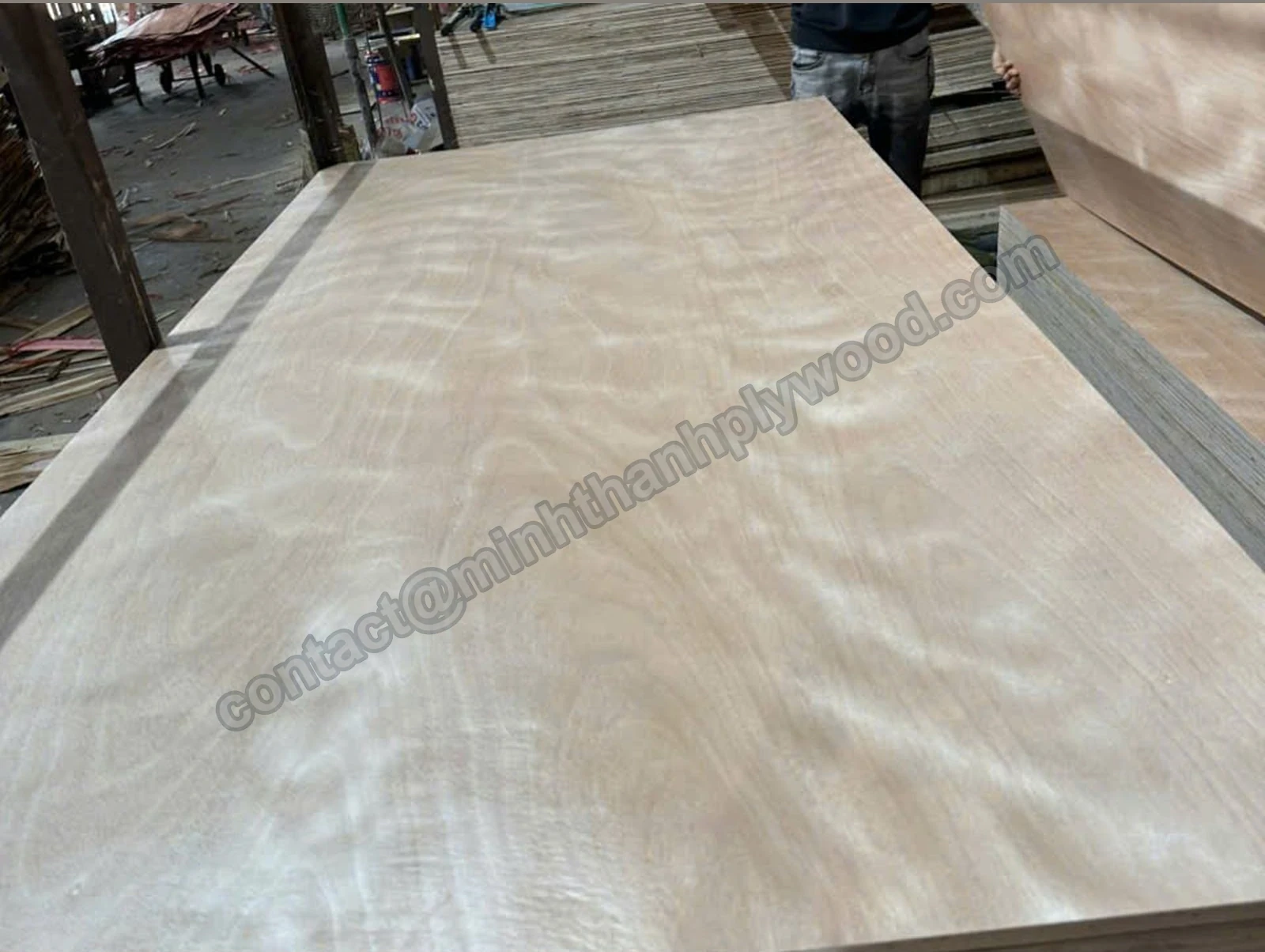 Okoume-faced plywood panel with pinkish figured grain on a stack