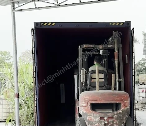 Forklift driving into a container with a plywood pack, filmed from the loading dock
