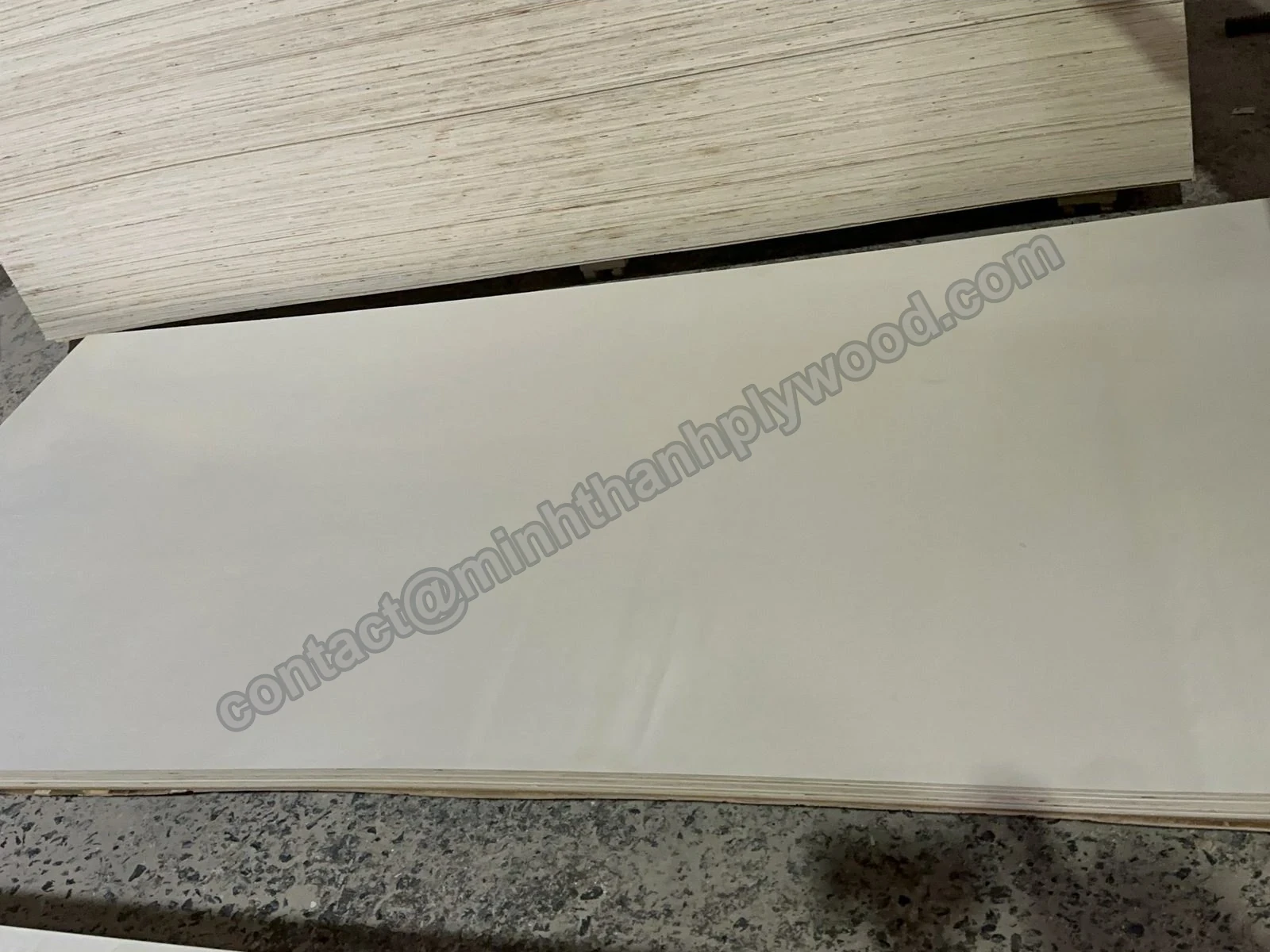 Tablero de triplay junto a un paquete con capas visibles en el canto