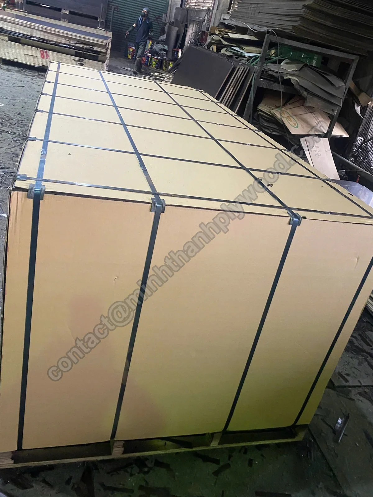 Plywood export packing: pack covered in kraft cardboard with steel straps on a plywood pallet