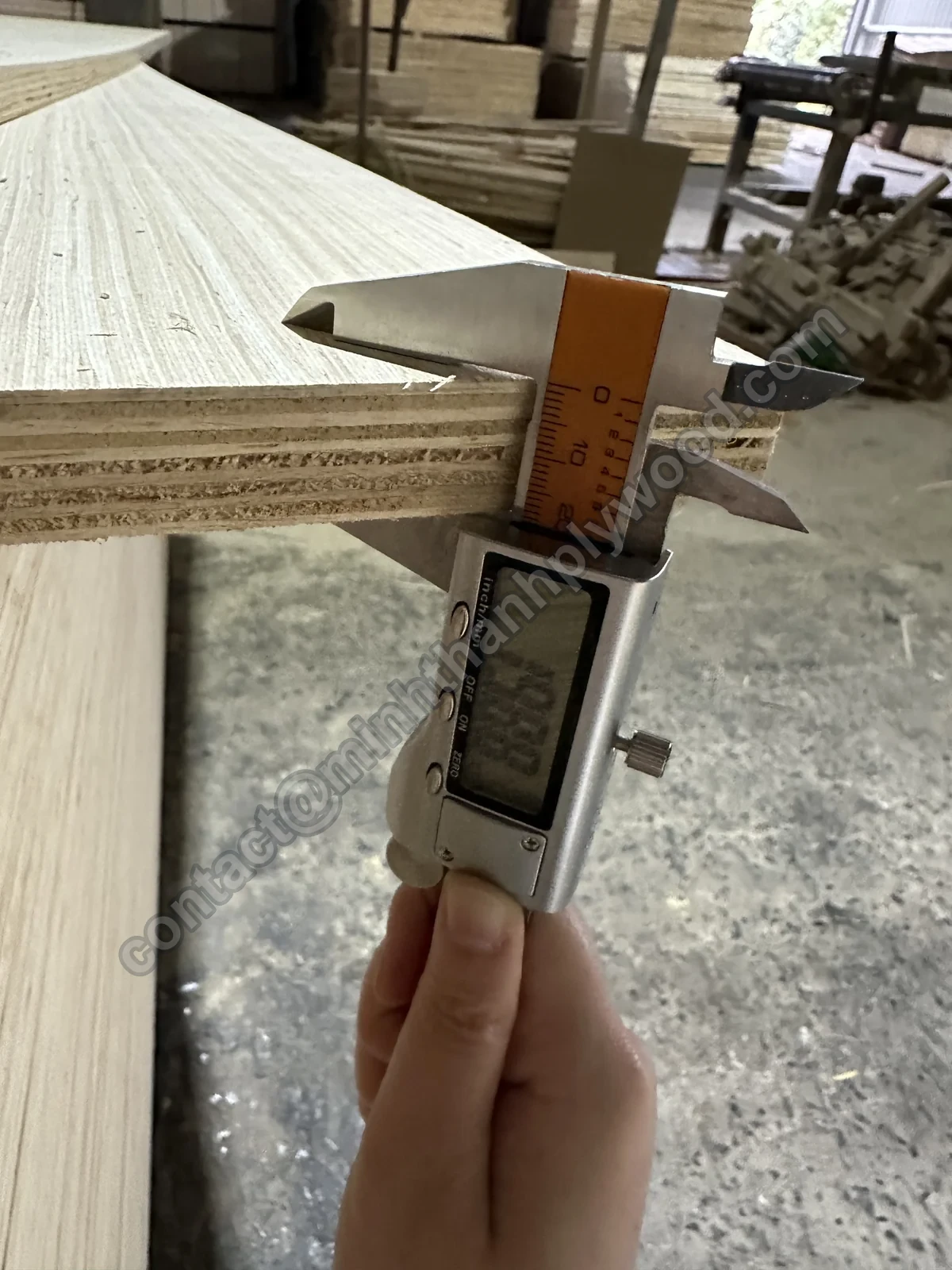 Digital caliper on the edge of a 20 mm engineered-veneer furniture panel
