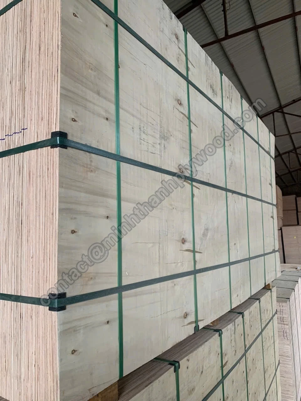 Plywood inspection before loading: strapped packs of finished plywood stacked in the warehouse