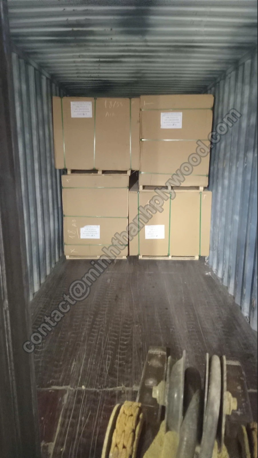Multiplexpakketten twee hoog tijdens containerladen, met heftruckklem op de voorgrond