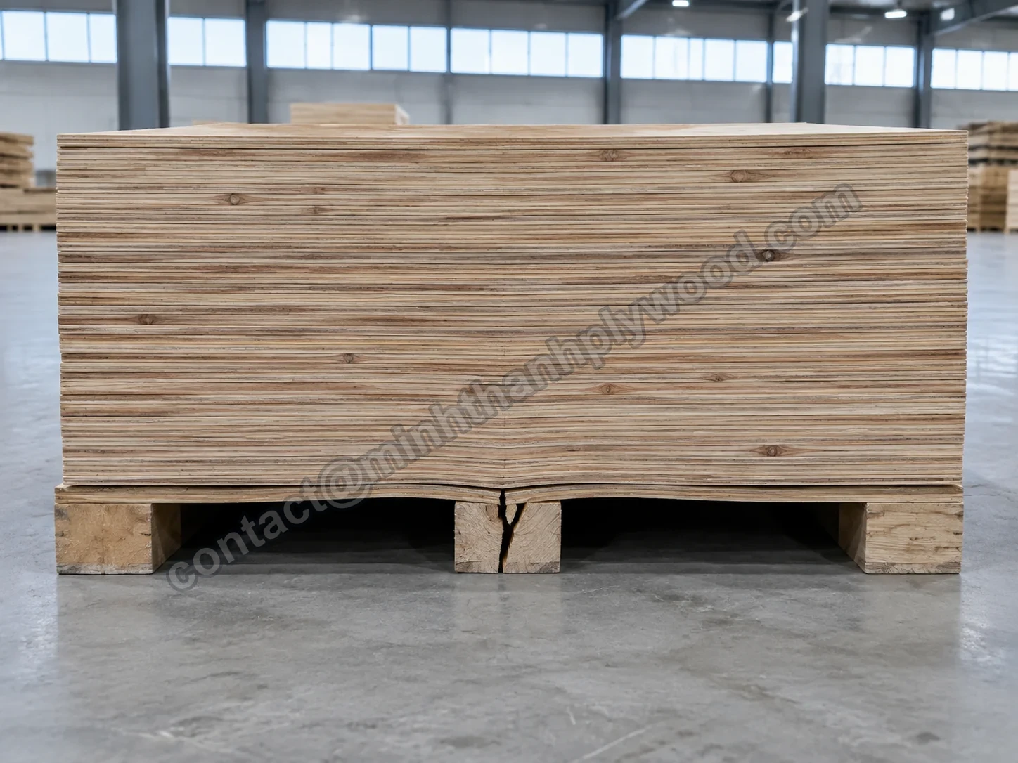 Tall overloaded plywood stack with a cracked bearer under the middle of the pallet