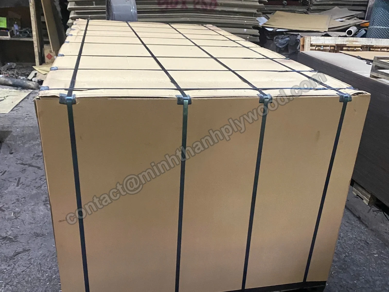 Plywood export pack covered in cardboard with steel straps on a pallet