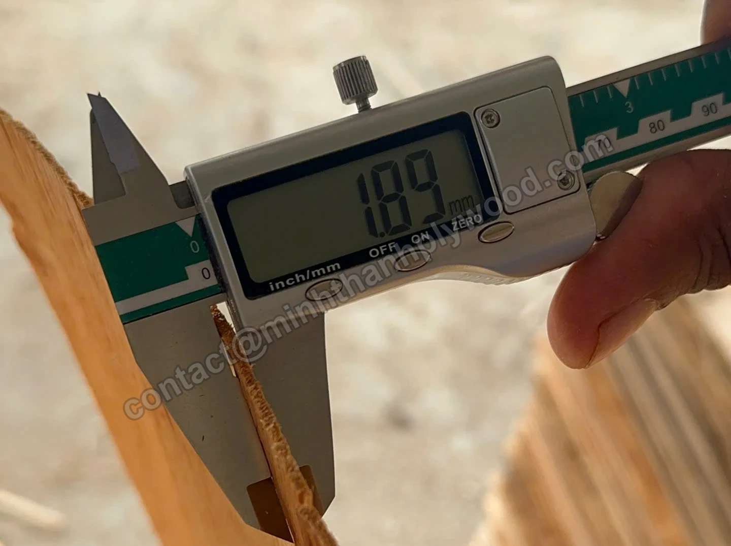 Veneer sorting by thickness: digital caliper reading 1.89 mm on a core veneer sheet